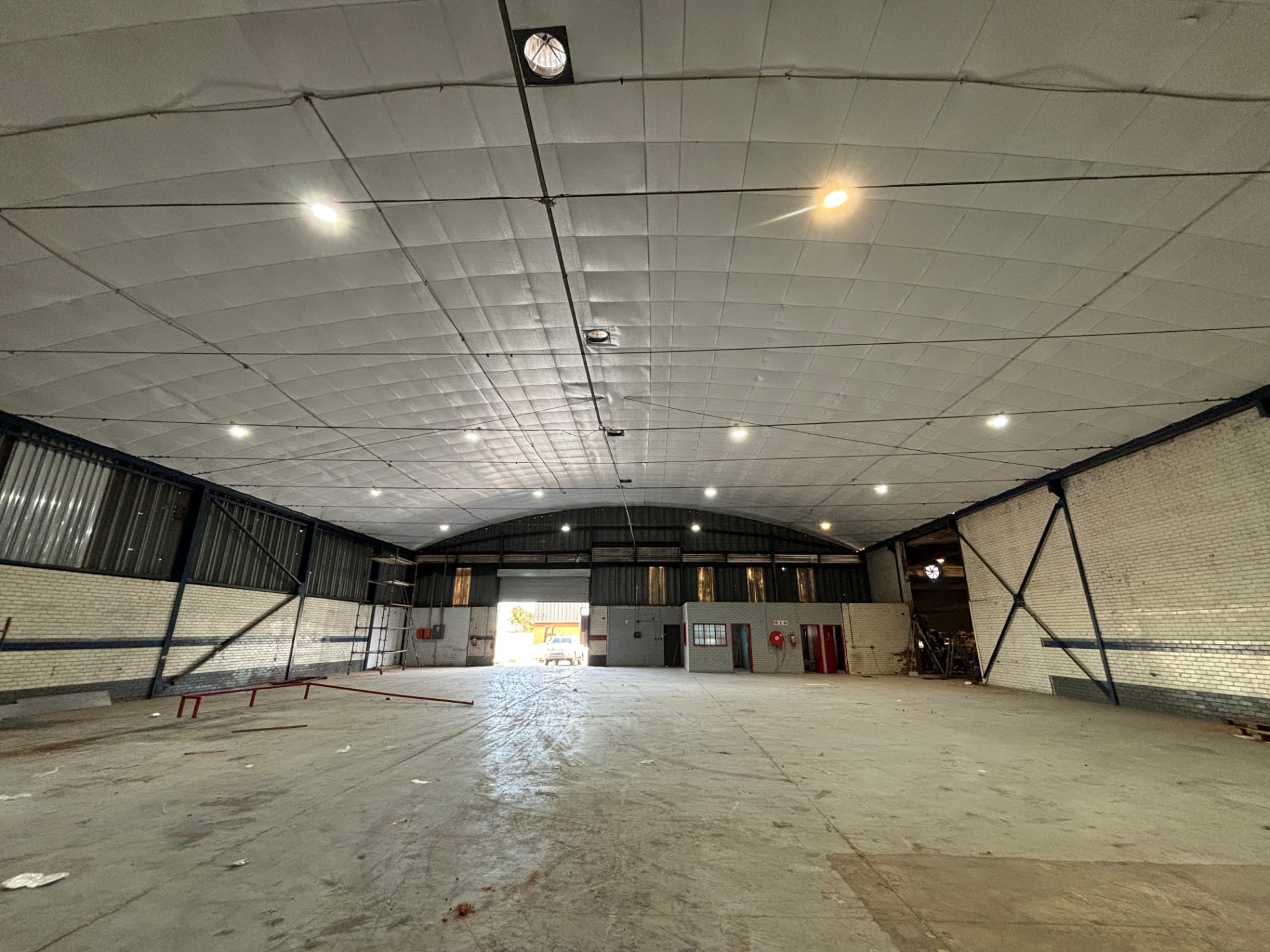 Empty industrial warehouse interior with vaulted ceiling and loading bay