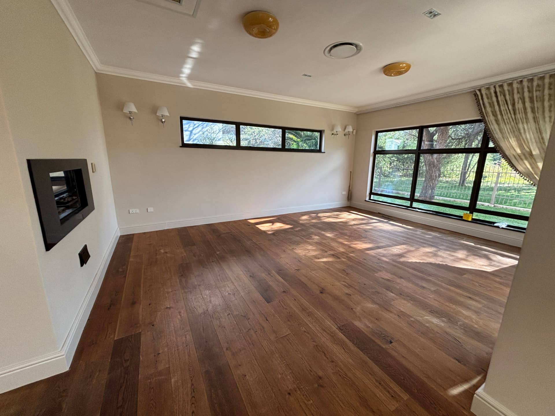 Repainted residential lounge with hardwood flooring and fireplace in Phakalane Golf Estate